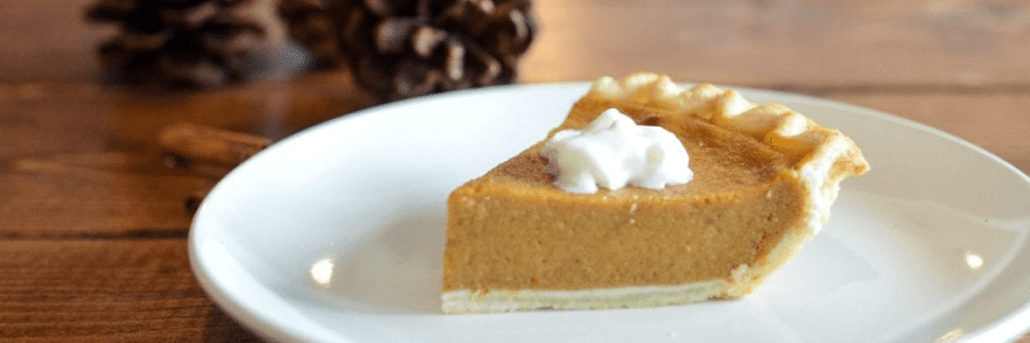 Slice of pumpkin pie on a white plate on a wooden table. Gratitude for Wellness. As we approach another Thanksgiving, we want to take a moment to reflect on the past year and all the changes that came with it.